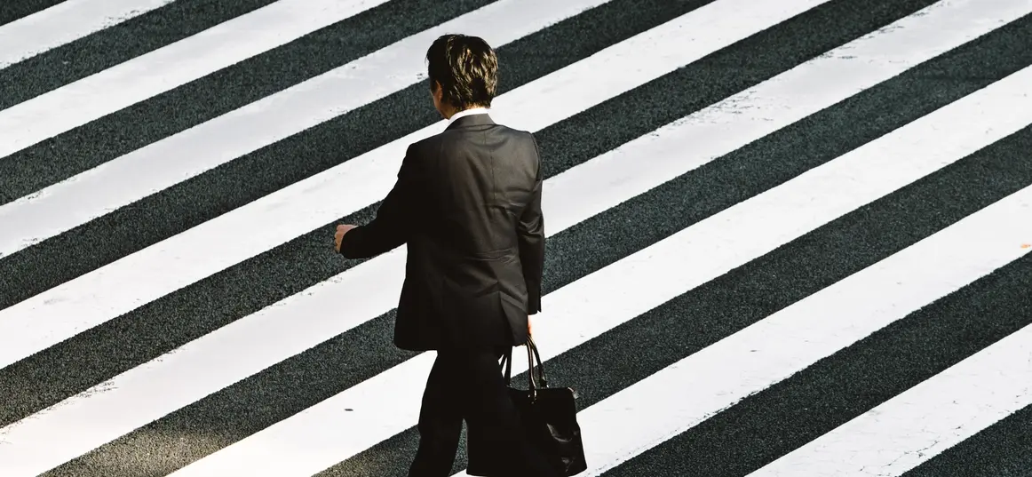 Photographie d'un homme d'affaire qui traverse un trottoir